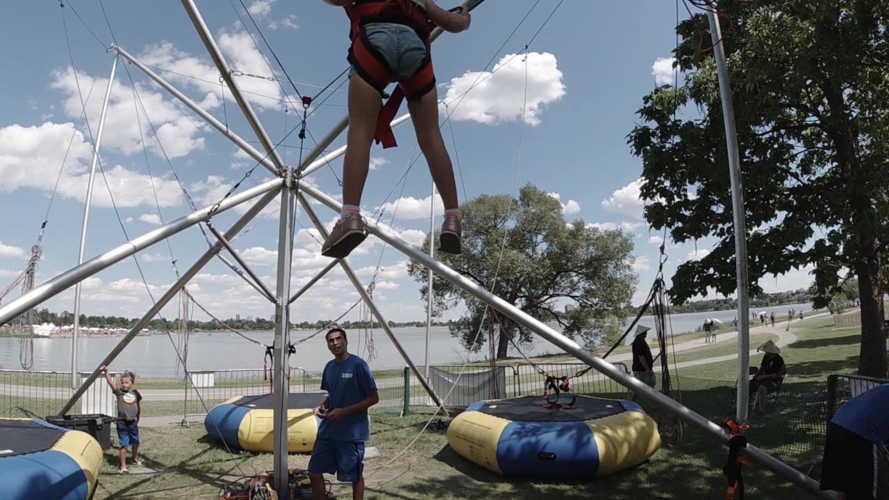 Girl suspended over bungee ride frame
