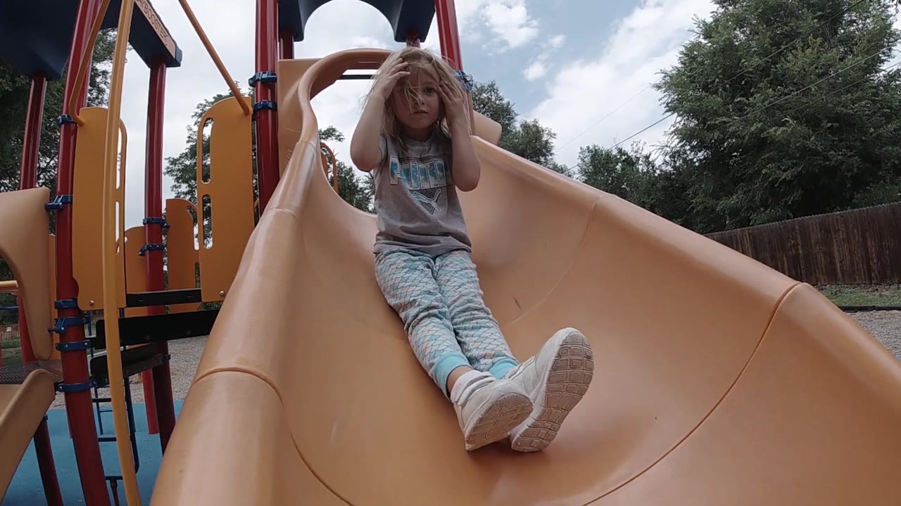 Girl sliding with her feet extended toward the camera.
