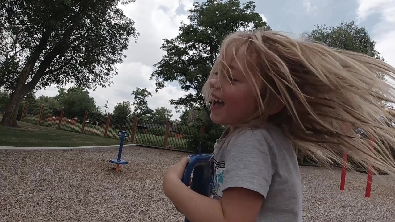 Child turns sideways with hair blowing outward.