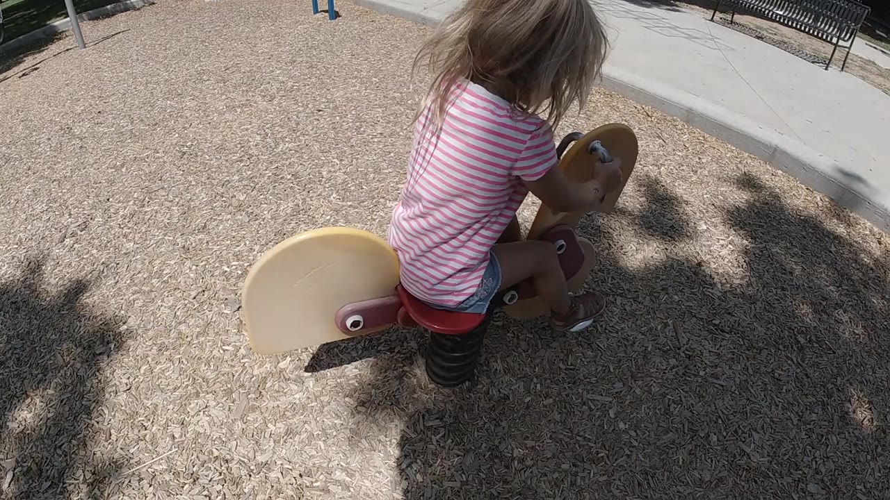 Blonde child on a playground spring rider