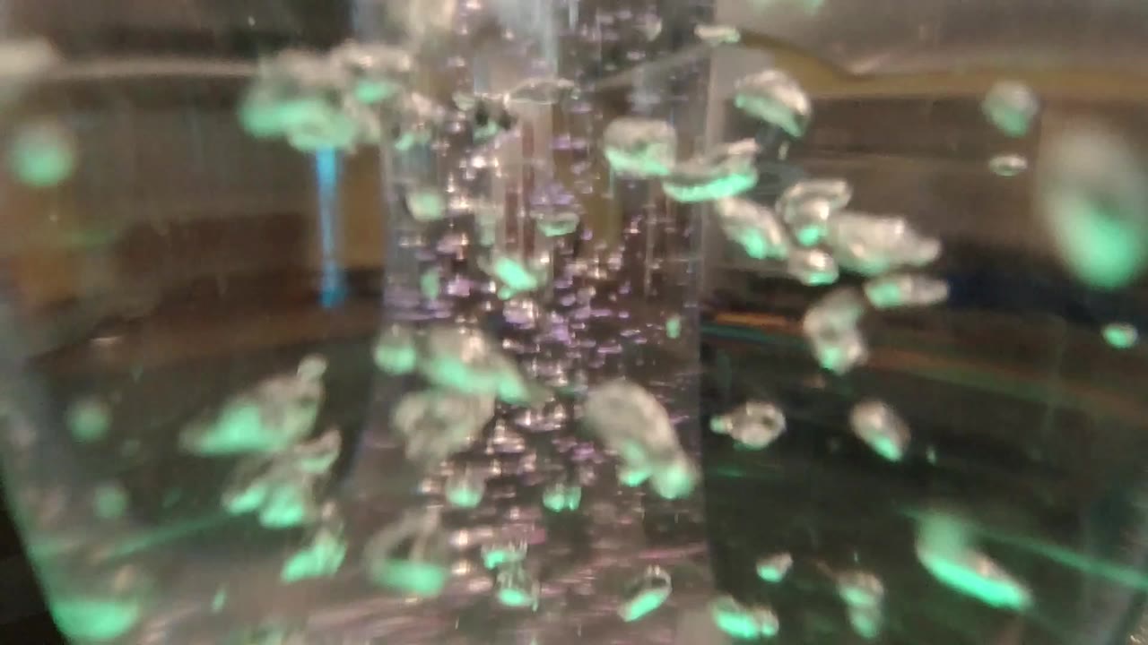 Green-lit bubbles inside a clear glass tube.