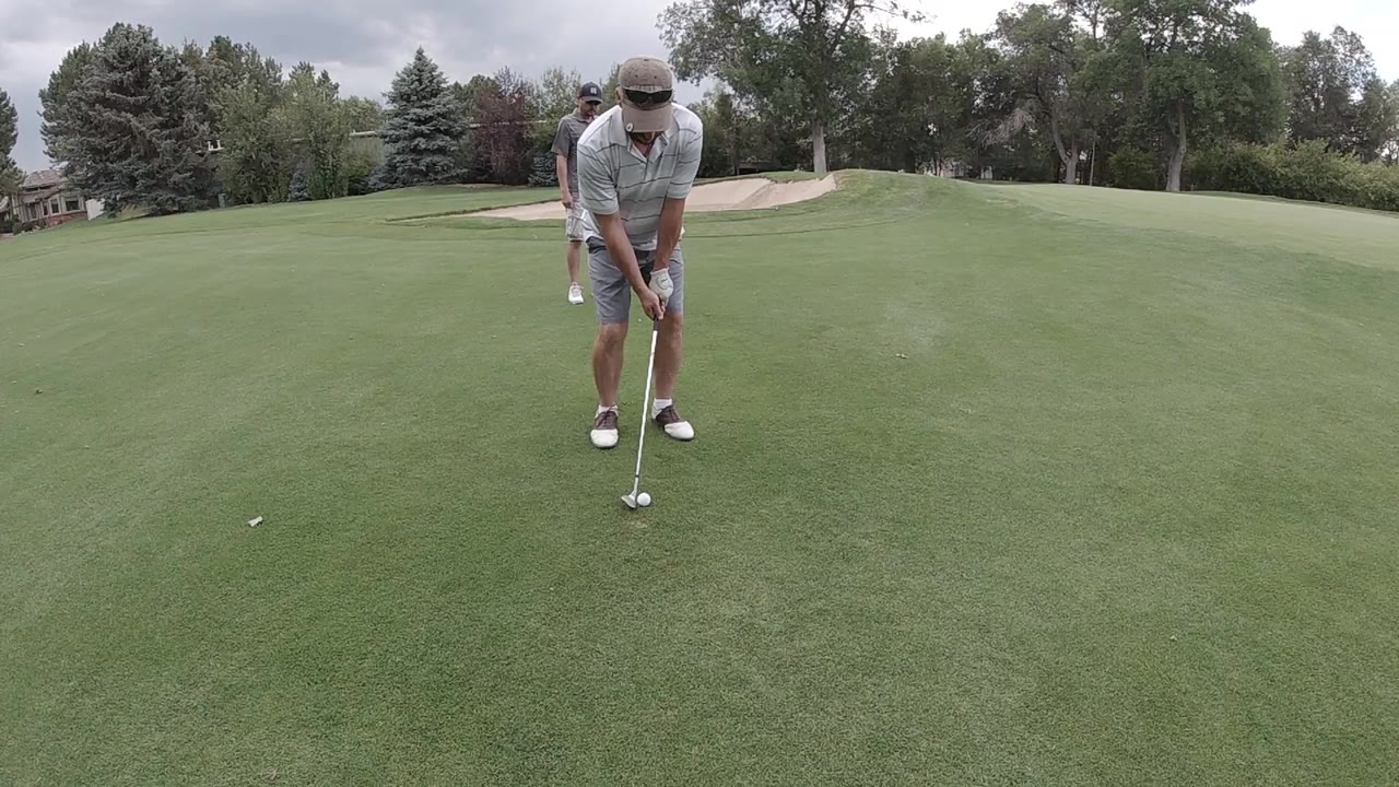 Man lining up a putt on a golf green