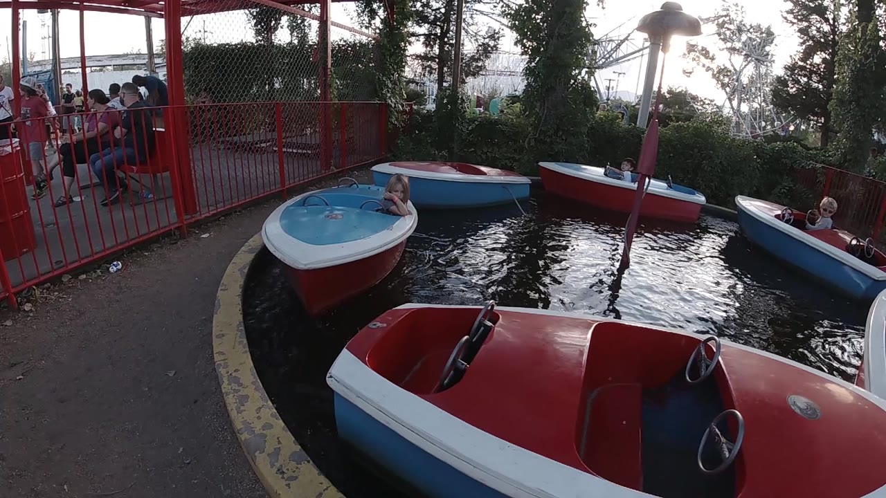 Children riding small boats on a water carousel