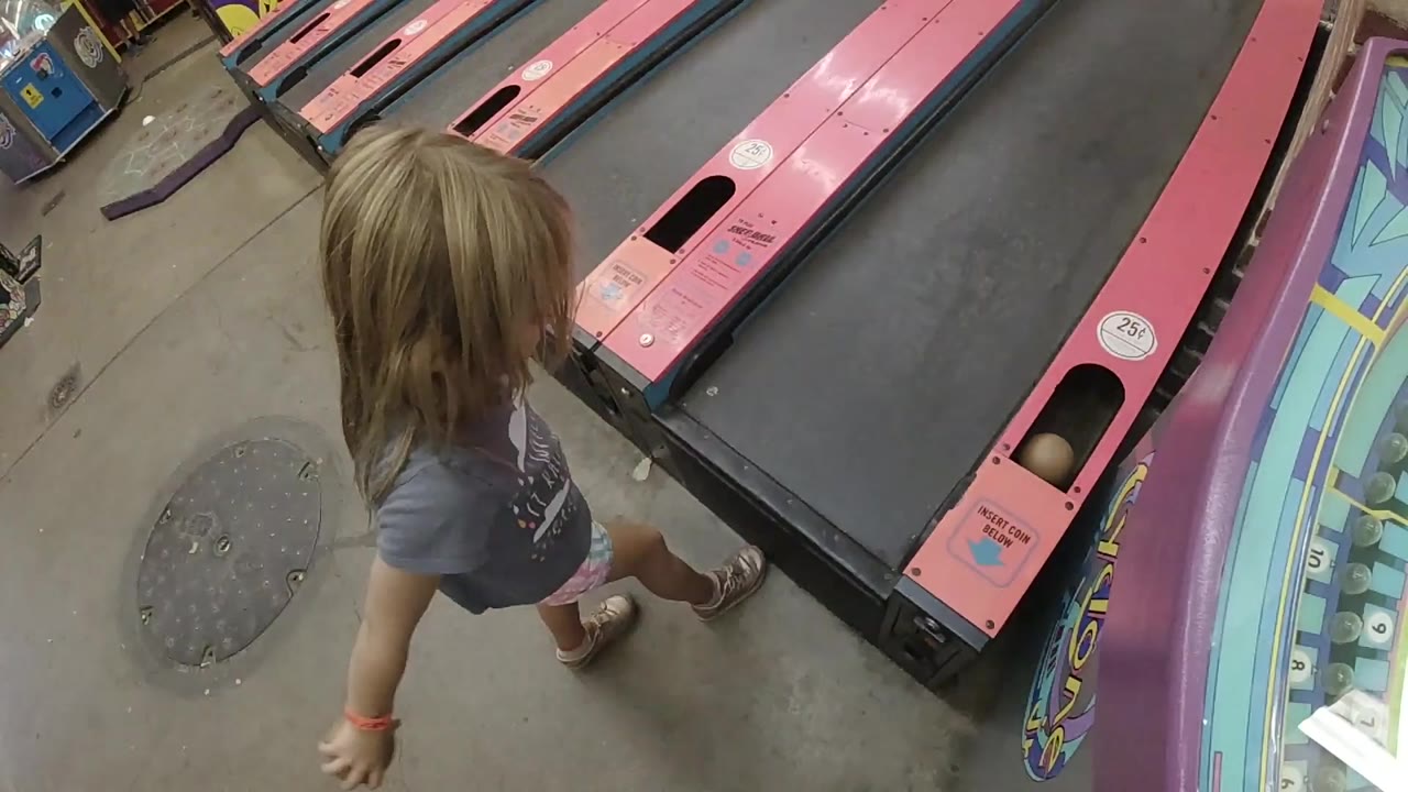 Girl stepping beside a skee ball ramp