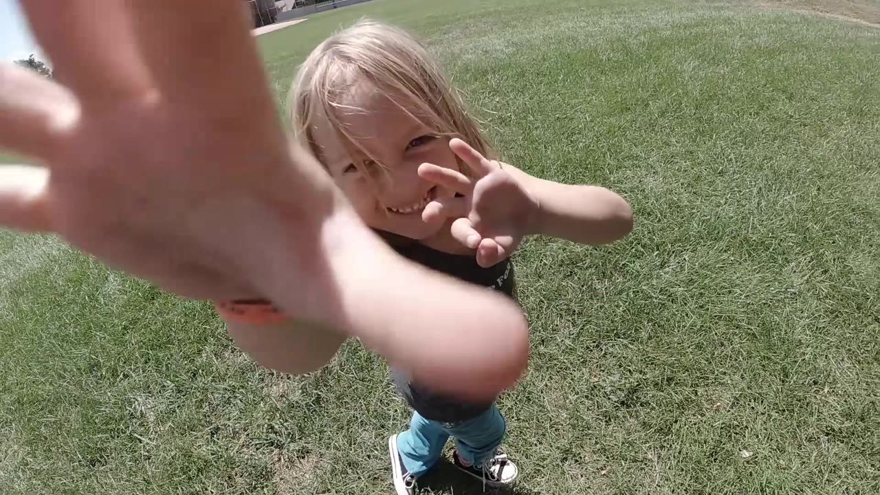 Girl reaches both hands toward the camera at close range.