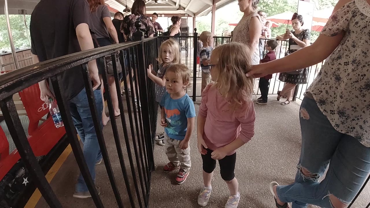 One second in, the children remain near the railing as a blonde girl looks forward and adults fill the covered platform behind them in Colorado.