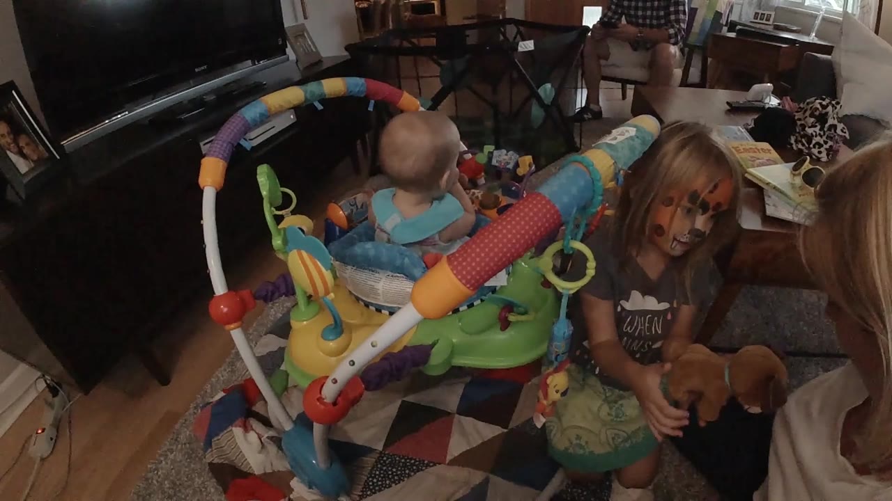 Older girl reaches down near plush toy beside jumper.