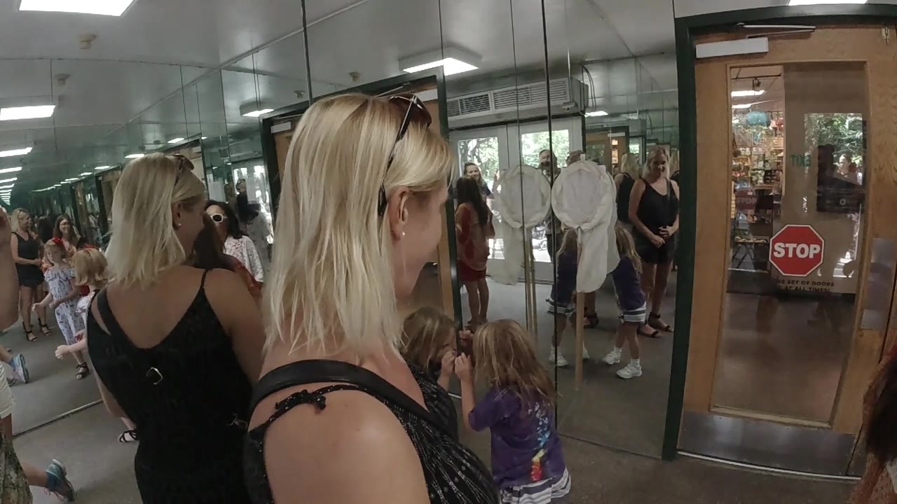 Woman turns slightly near a child in an indoor doorway area.