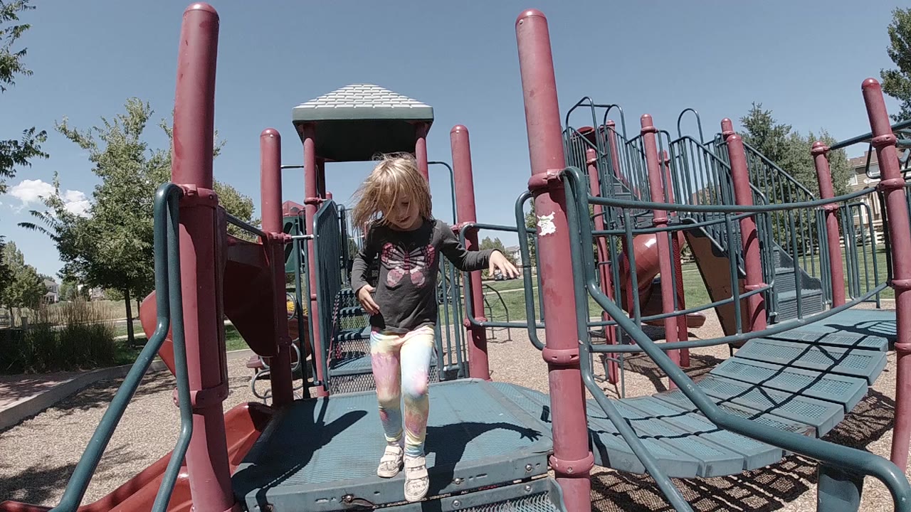 Young girl stepping from a playground platform.