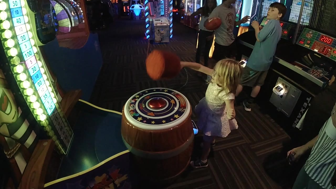 Red mallet hangs above the arcade target as people watch.