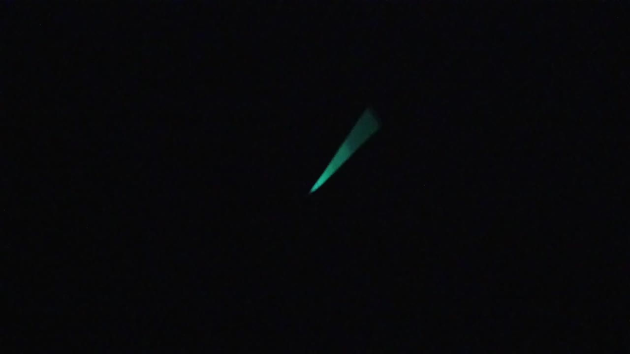 Near-black frame with small teal-green glowing marks distributed across the left and center areas.