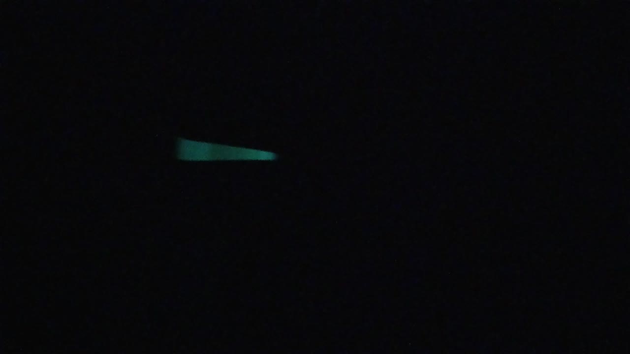 Opening frame with a few turquoise-green light streaks scattered across a nearly black field in Colorado footage, no visible people.