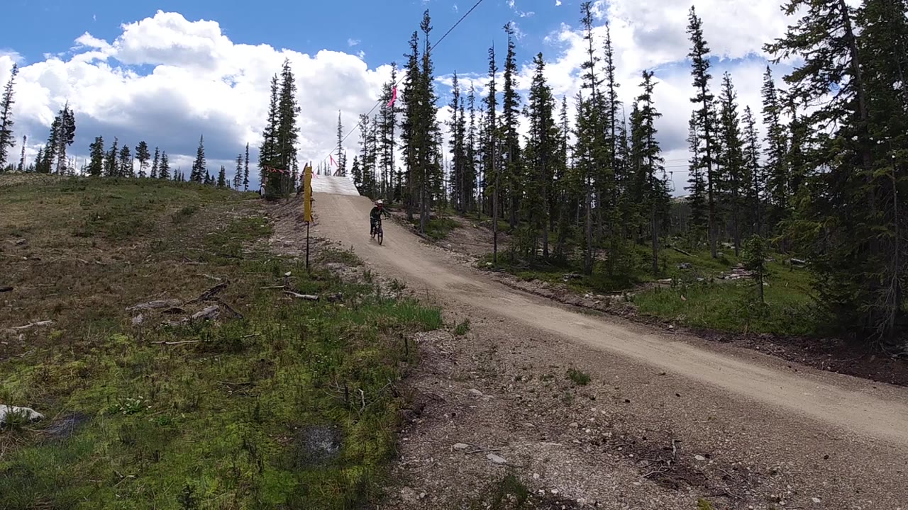 Cyclist riding downhill on a pale dirt trail.