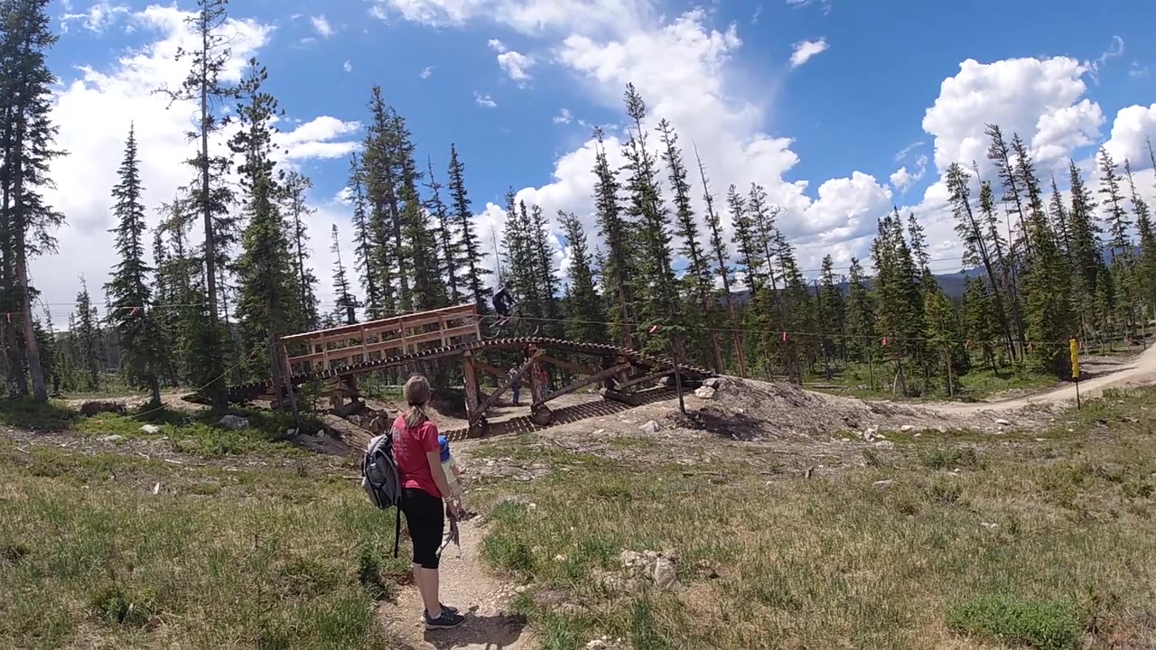 Hiker approaching bridge on open mountain path