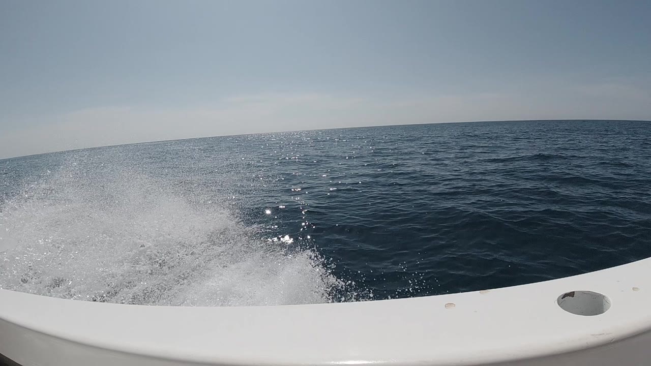 Foam spray beside boat rail on blue water
