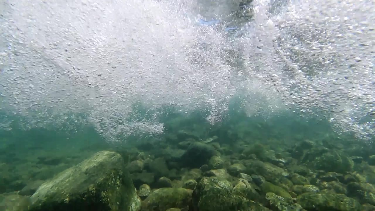 Dense white foam and bubbles viewed from at or just below the water surface