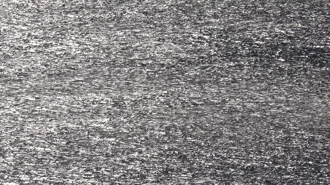 A second view of the Malibu reflective surface shows bright silver flecks spread more evenly across the dark gray frame, with no visible people.