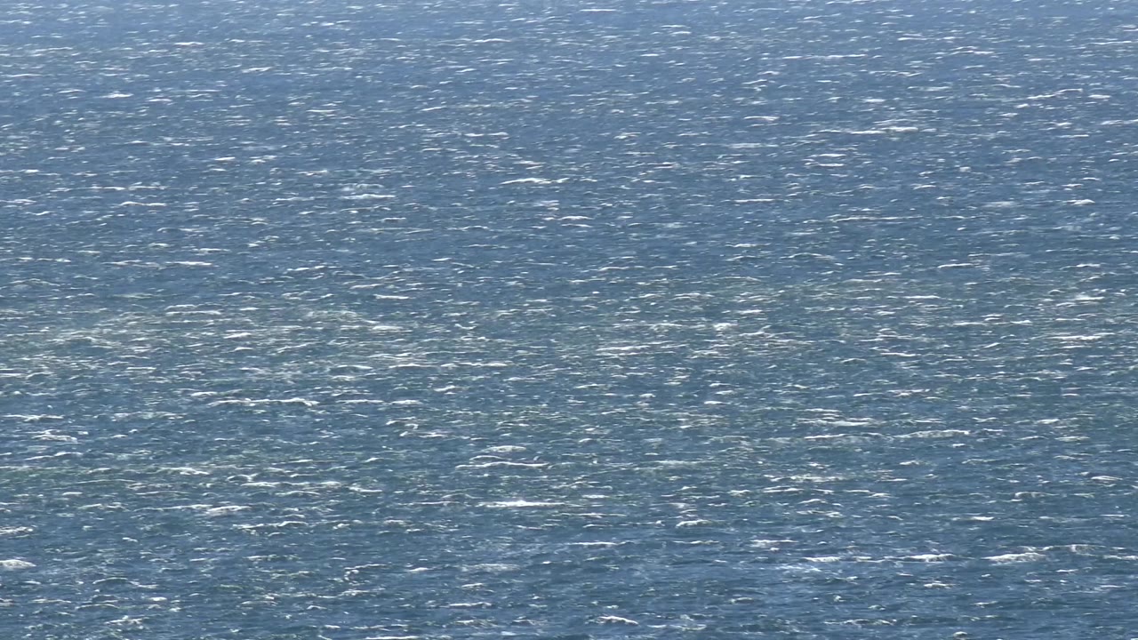 The Malibu seawater remains tightly framed, with softer reflections spread across the rippled blue surface and no visible people.