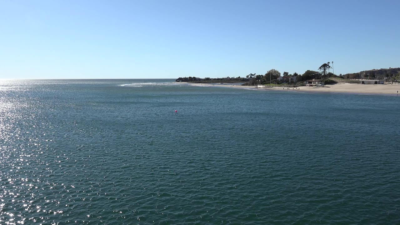 Ocean foreground with bright reflection and sandy coastline