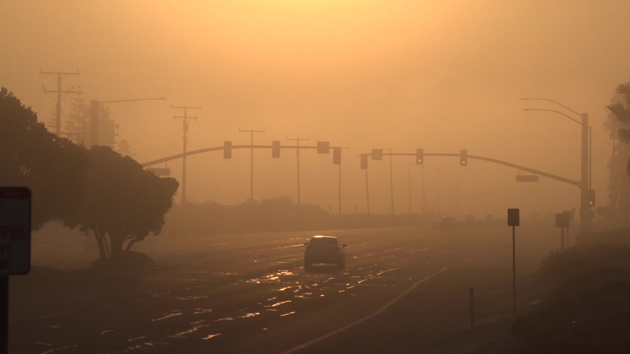Roadway under orange haze with a car near the right lane