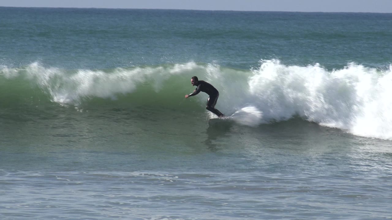 Surfer rides ahead of breaking whitewater.