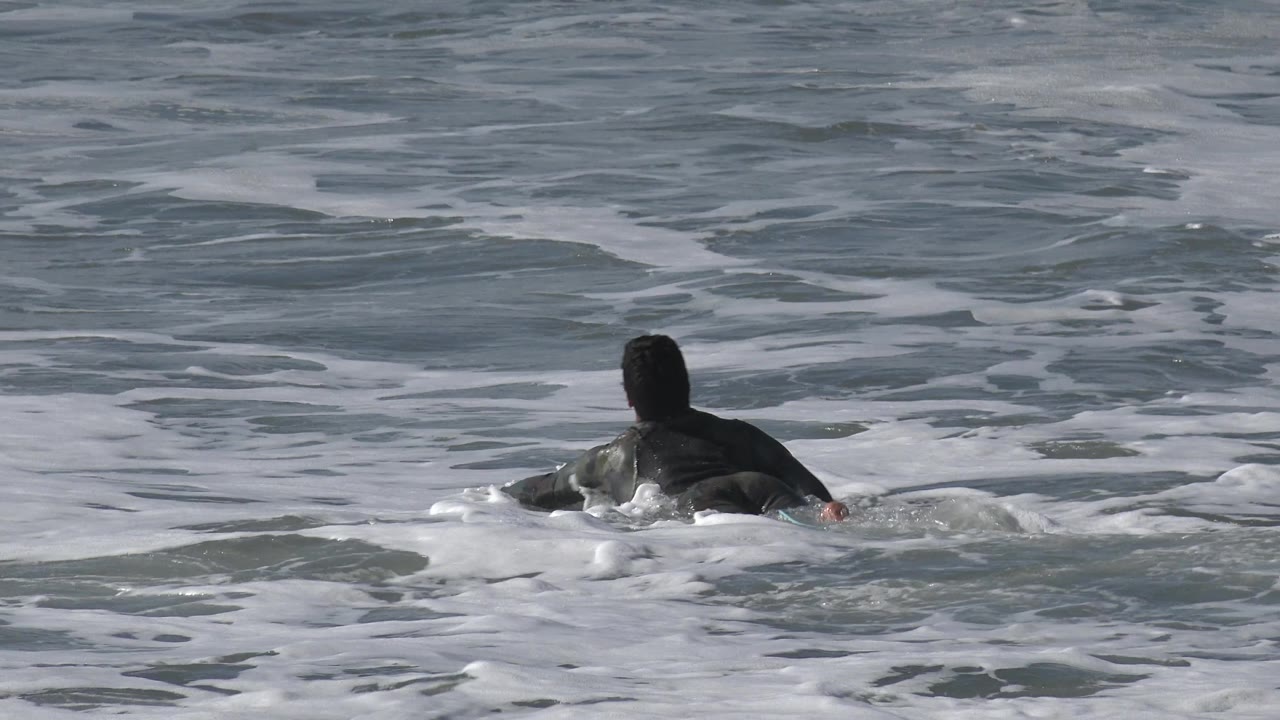 Swimmer low in the water with foam in foreground
