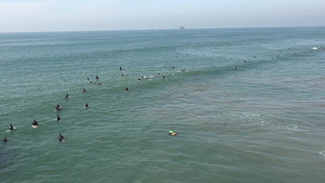 Surf lineup with one brighter board in the lower water.