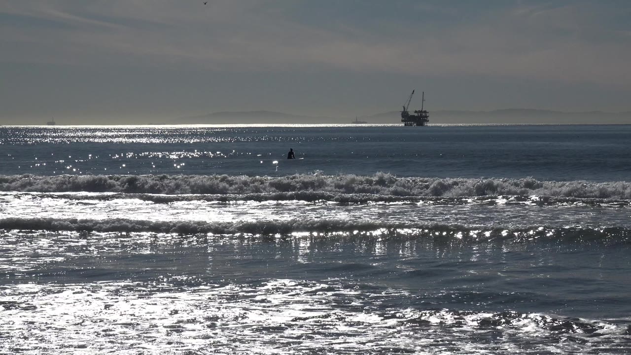 Bright surf and distant offshore structure on the horizon.
