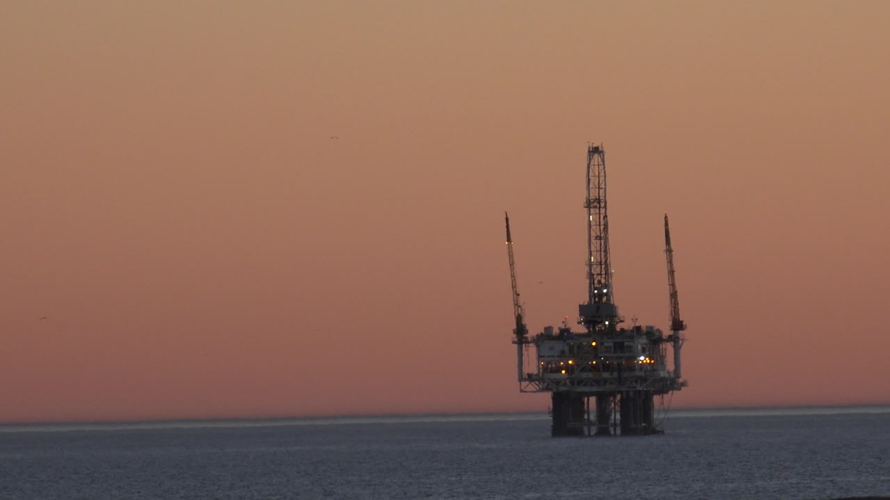 Platform over the sea with warm sky and distant birds.