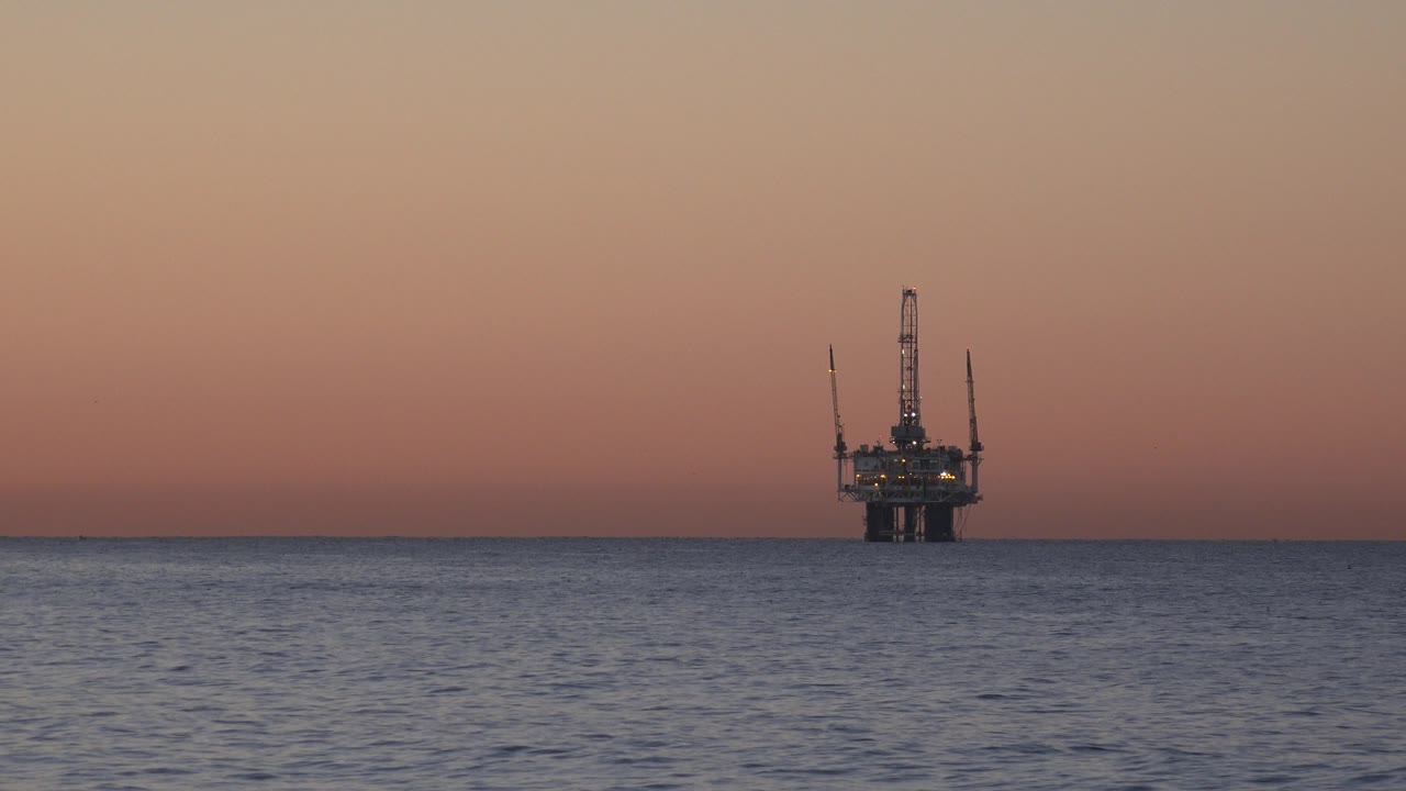 Offshore platform at right over calm ocean water