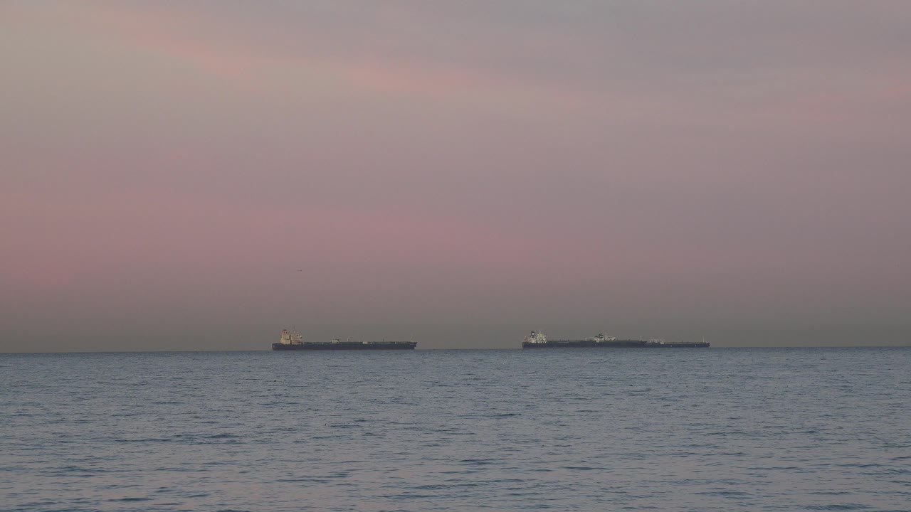 Offshore tanker ships on a calm sea horizon.