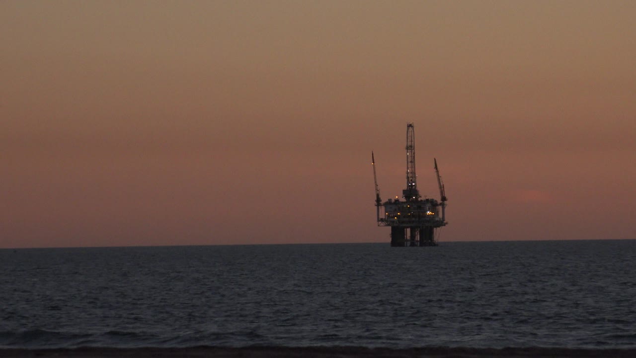 Oil platform near the right side of the sunset horizon.