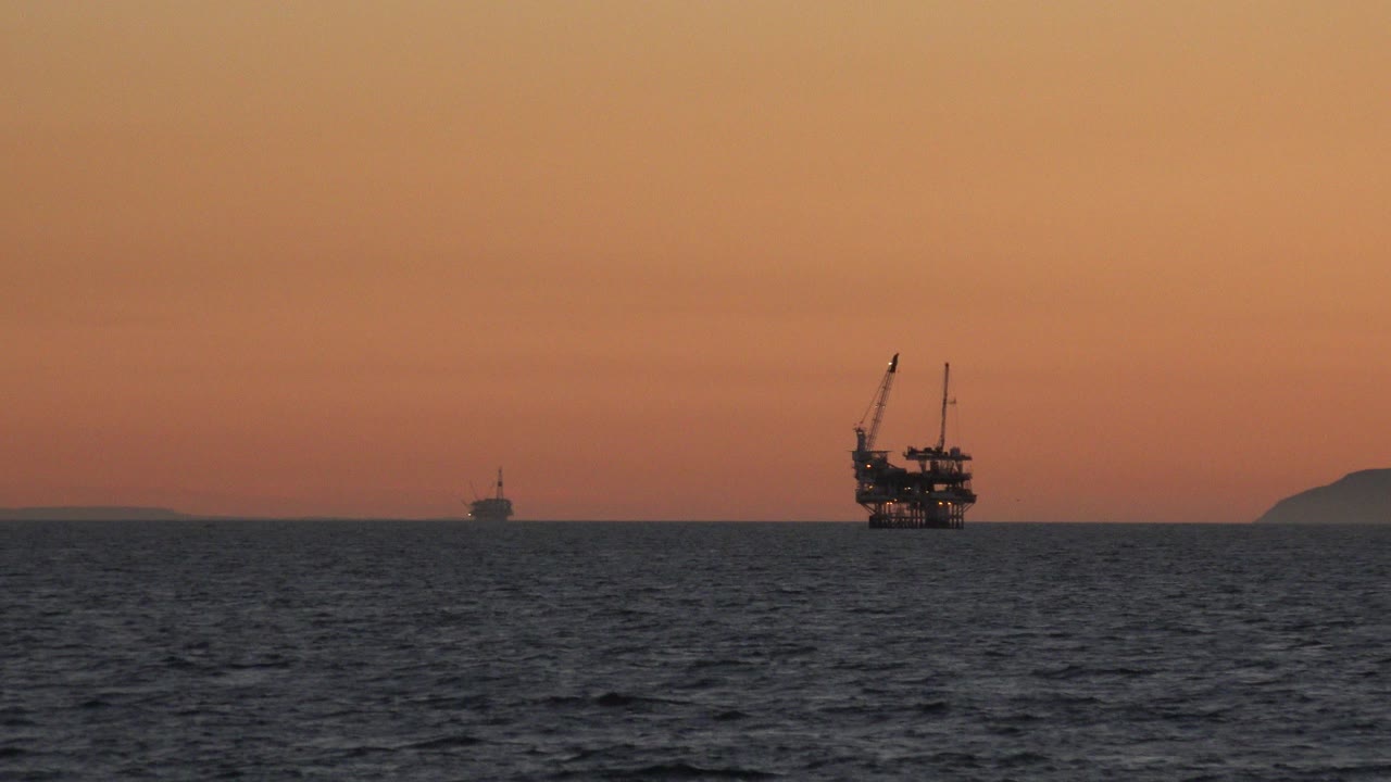 Offshore platform silhouette on the ocean at sunset.