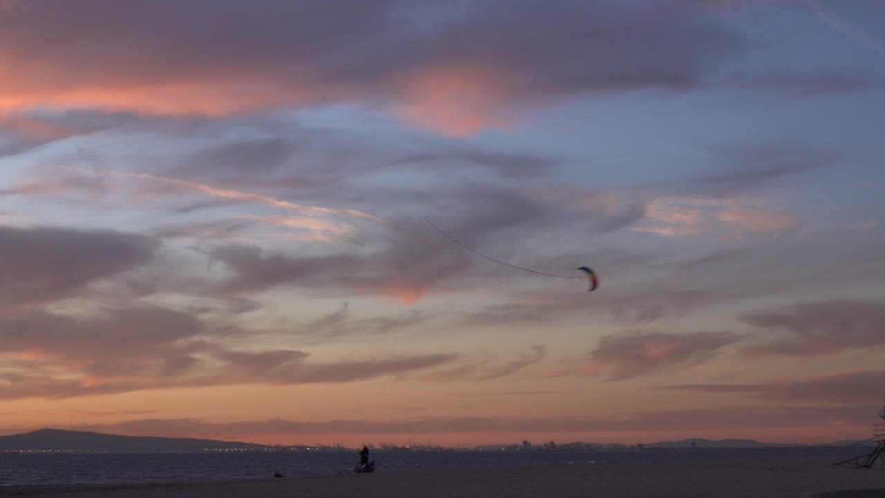 Dusk beach horizon with a small kite in the sky.