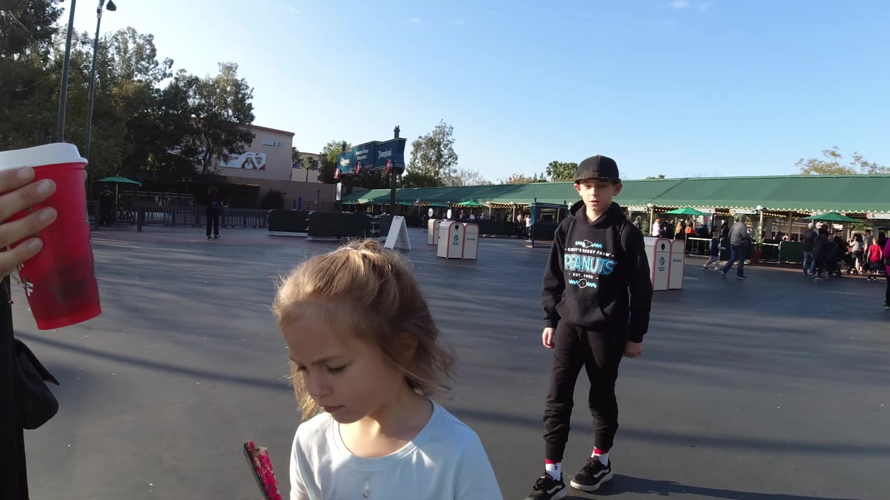 Girl looking down while boy stands on plaza