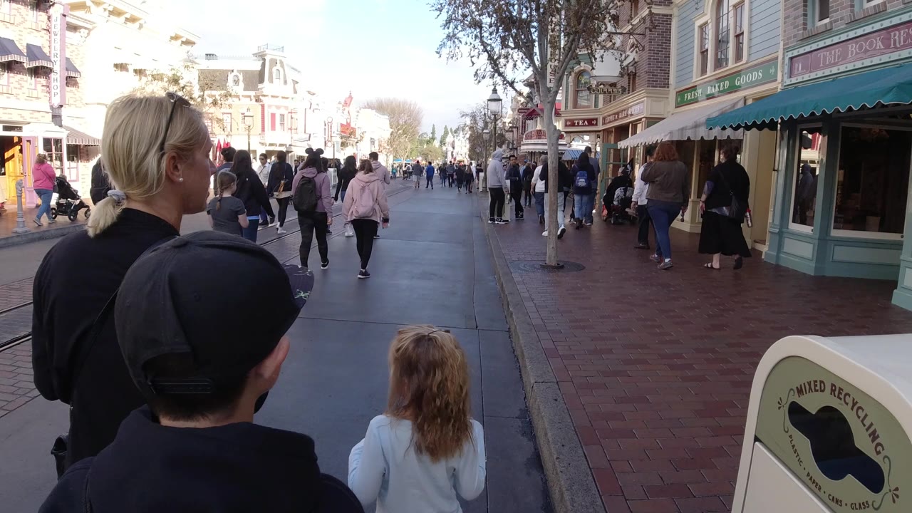 Family walking past storefront awnings and pedestrians.