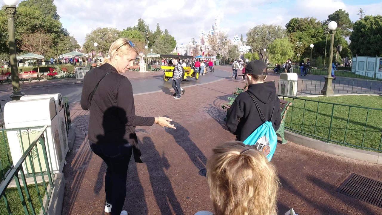 Woman glancing back while children walk ahead on the park path.