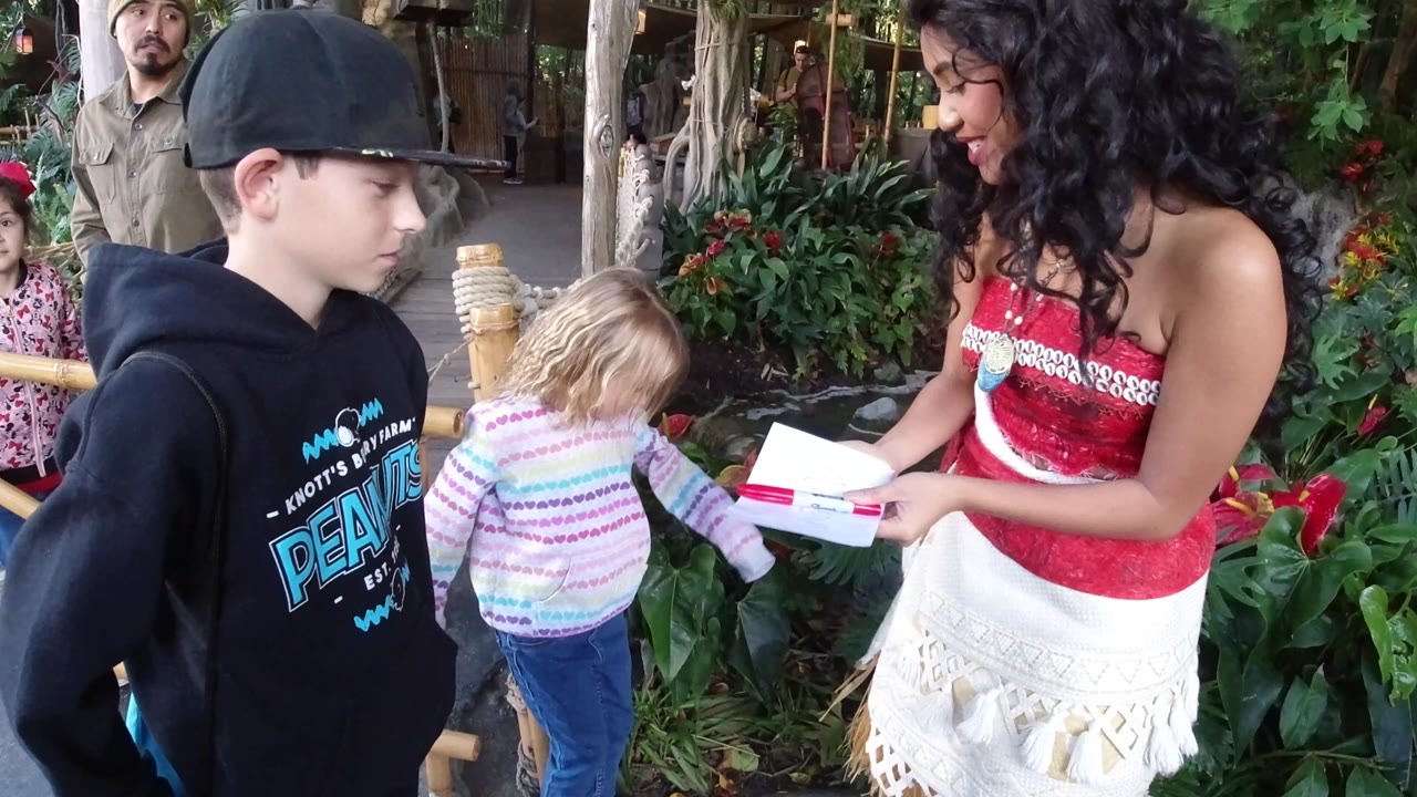Performer lowers paper toward the children.