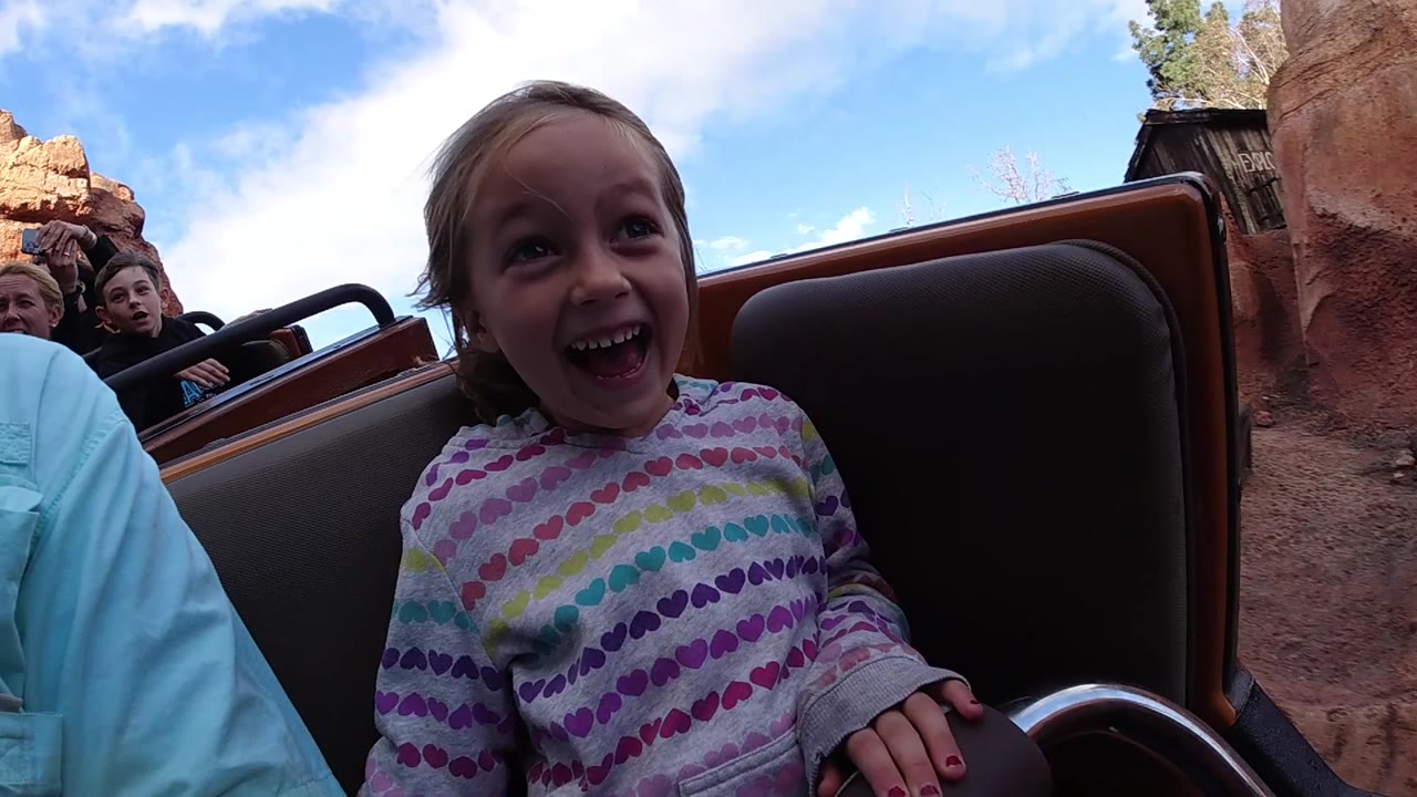 Child smiling while seated in front of other riders.