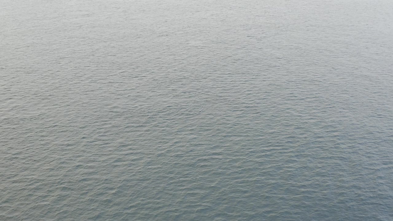 Calm Baja California Sur water covers the frame at 0:01, with fine ripples and a slightly darker blue band near the lower edge, no visible people.