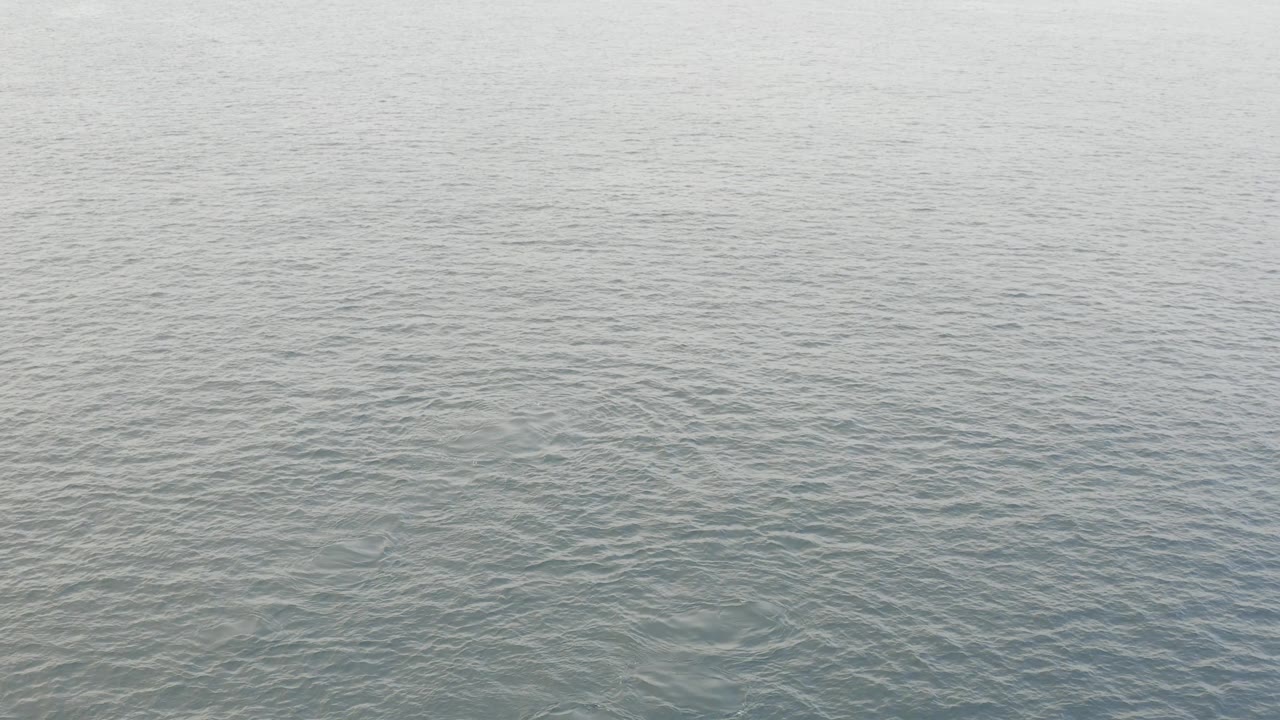 Baja California Sur aerial frame with calm blue green sea covering almost the entire image and no visible people, boats, or structures.