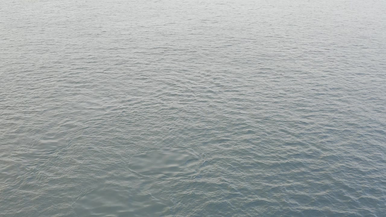 Pale blue-green ocean water fills the frame in Baja California Sur, Mexico, with fine ripples and no visible people.