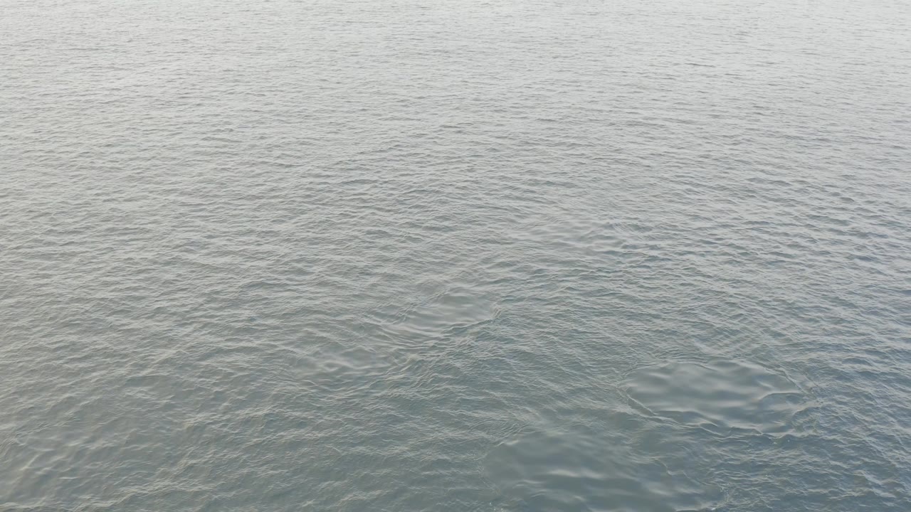 Light-toned water in Baja California Sur, Mexico, fills the frame with diagonal ripple texture and no visible people.