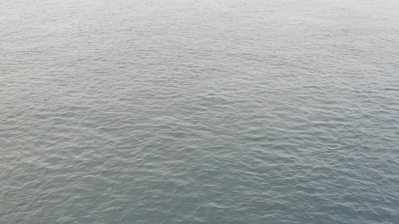 Dark green gray water fills the Baja California Sur frame with fine wave texture and subtle tonal variation, and no visible people.
