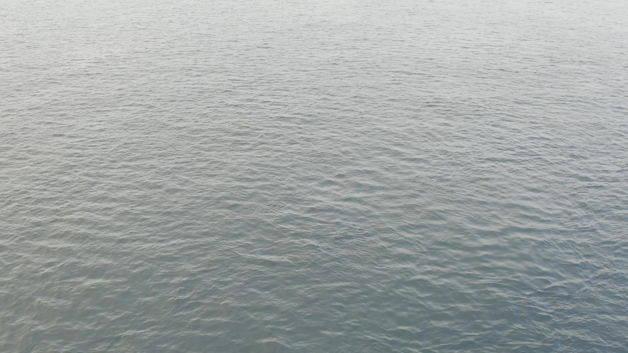 Calm ocean ripples in Baja California Sur show a broad soft highlight near the upper frame, with the view limited to water and no visible people.