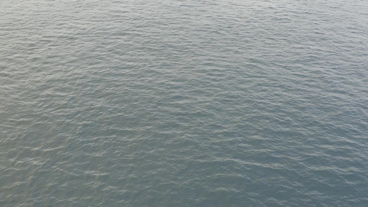 Muted blue green sea surface in Baja California Sur, Mexico, covered by small overlapping ripples with no visible people.