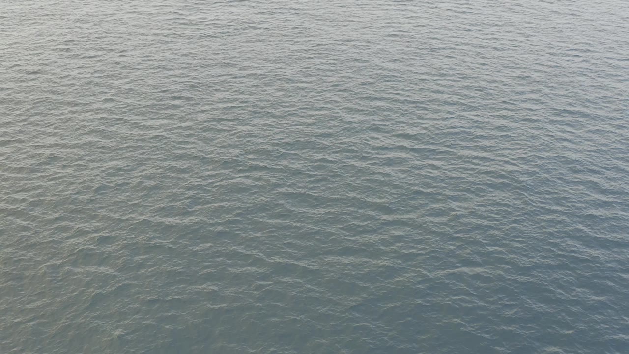 Aerial view of textured turquoise ocean in Baja California Sur, with darker underwater patches and no visible people.