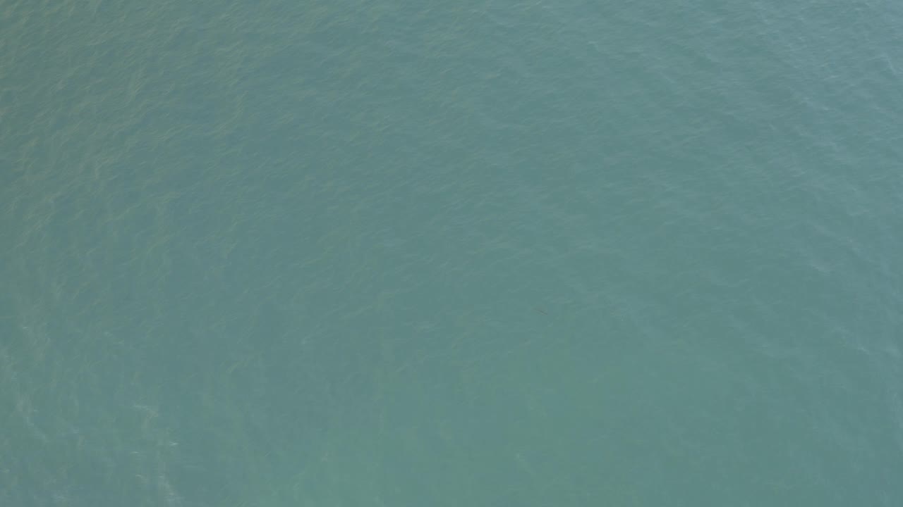Straight-down ocean view in Baja California Sur, Mexico, showing muted teal water texture and no visible people.