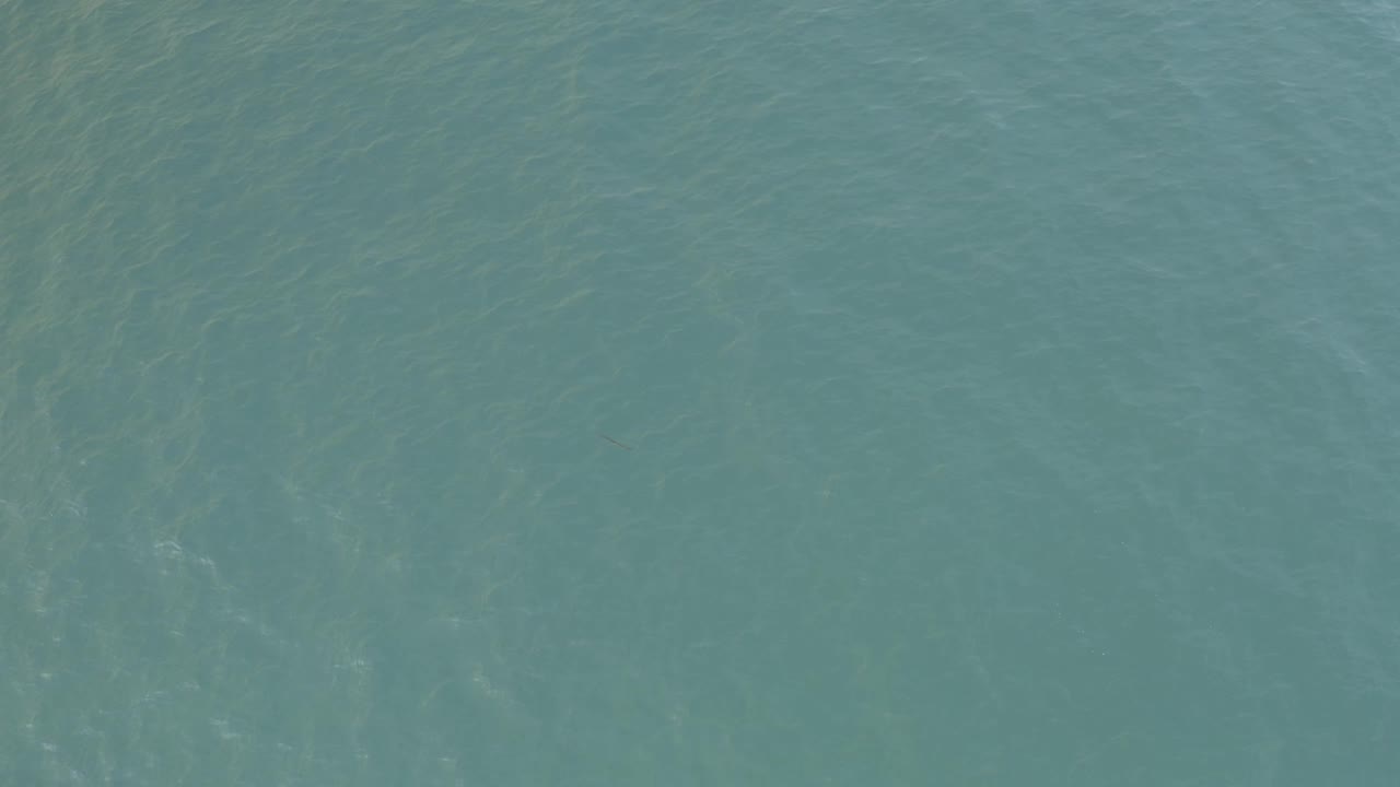 Teal ocean water in Baja California Sur, Mexico, with soft surface variation, faint vertical light streaks, and no visible people.