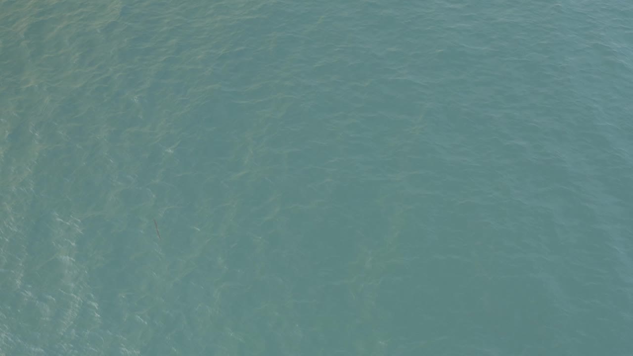 Turquoise ocean water in Baja California Sur, Mexico, with pale reflected streaks running through the surface and no visible people.